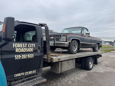 Classic Chevrolet pickup secured on a Forest City Roadside flatbed tow truck