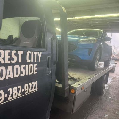 Ford Escape on a flatbed delivered into a service garage